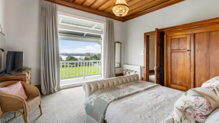 Bedroom with timber wardrobe and garden view, The Huntly House, Clarks Beach